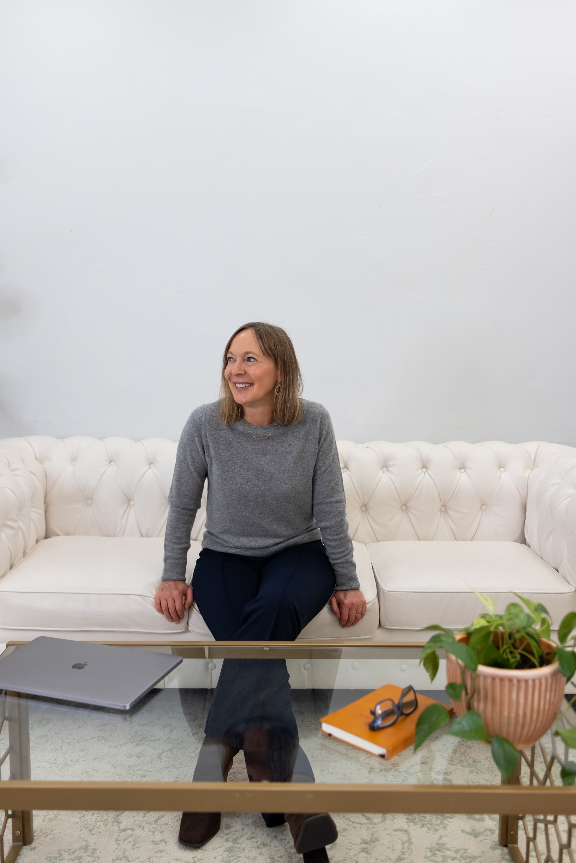 Susie seated on a cream sofa